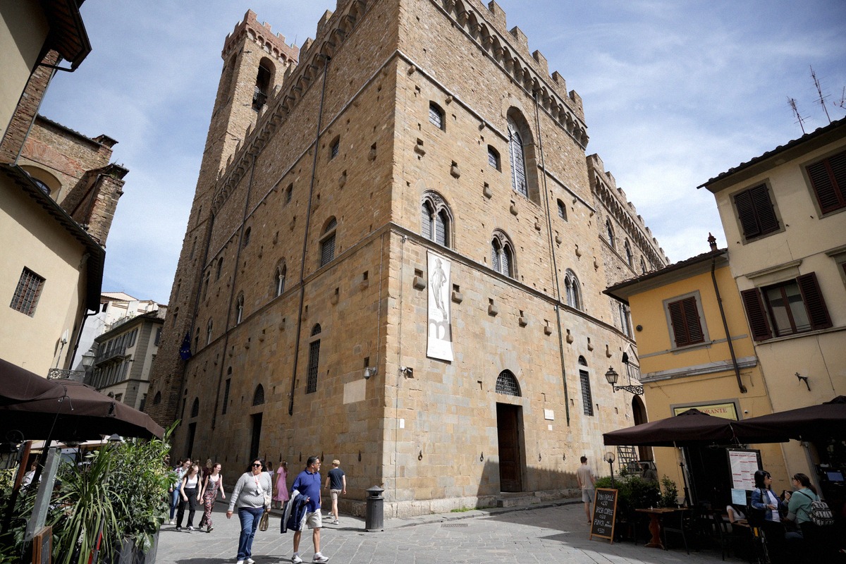 The rusticated facade of the Bargello with visitors on the square in front.