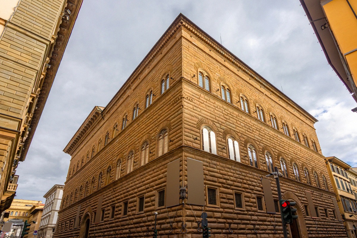 The Palazzo Strozzi seen across its corner, rusticated blocks over three storeys and rows of mullioned windows.