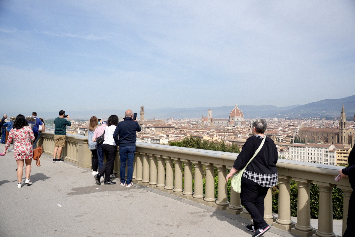 Visitors photographing the Florence skyline from the balustrade of Piazzale Michelangelo.