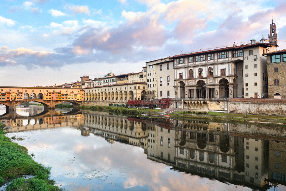 The Ponte Vecchio over the Arno at sunrise, with the Vasari Corridor and the Uffizi behind.