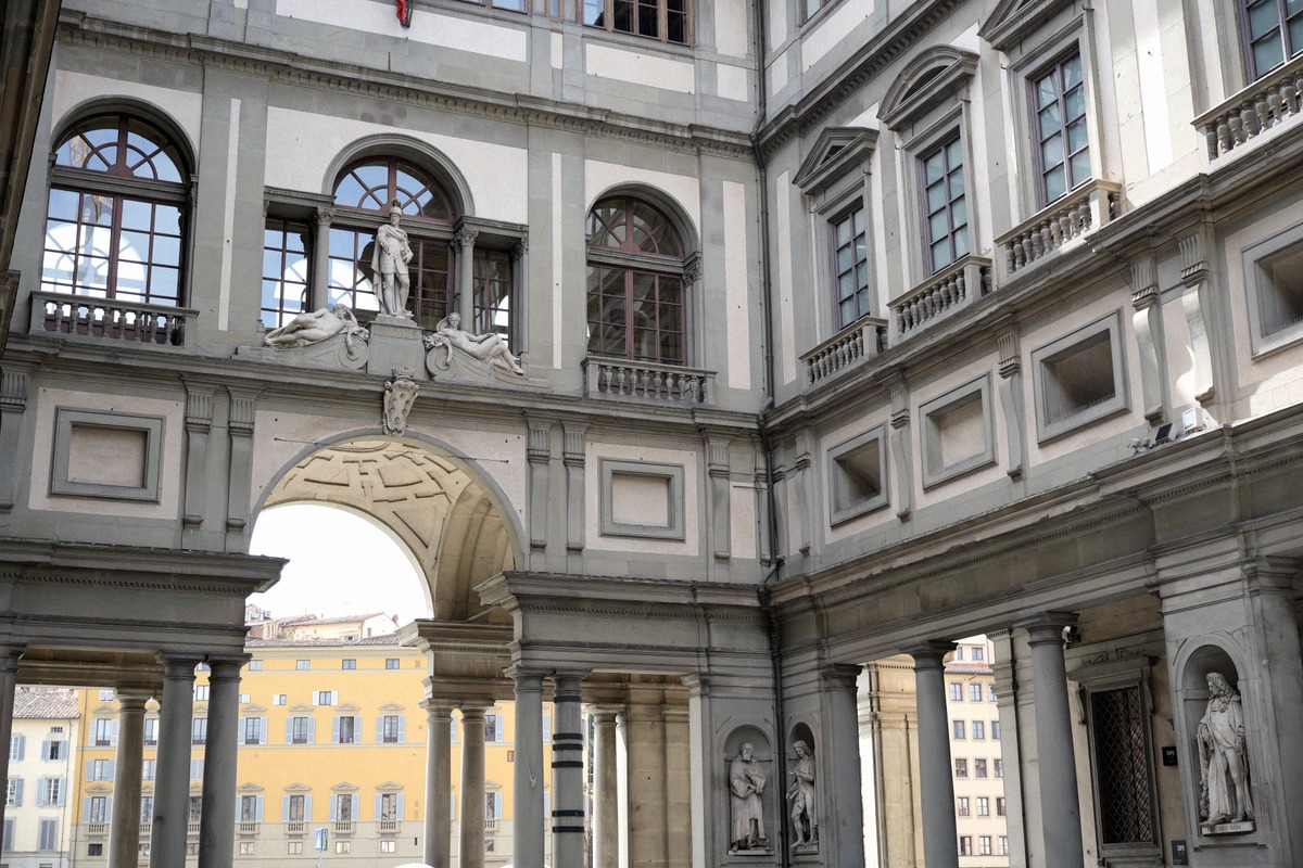 The courtyard of the Uffizi Gallery with the arcades of the gallery facade and the view through the archway.